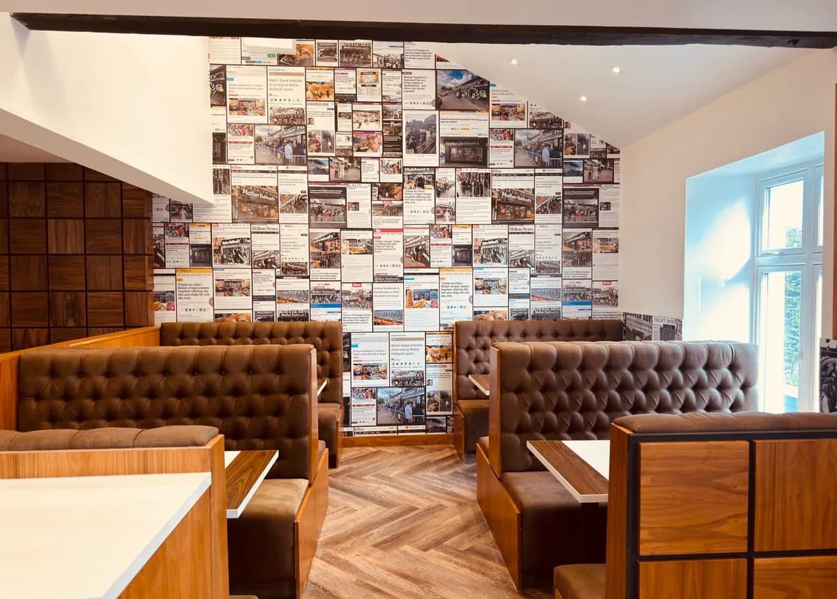Booths below a wall of press cuttings about Mother Hubbard's openings