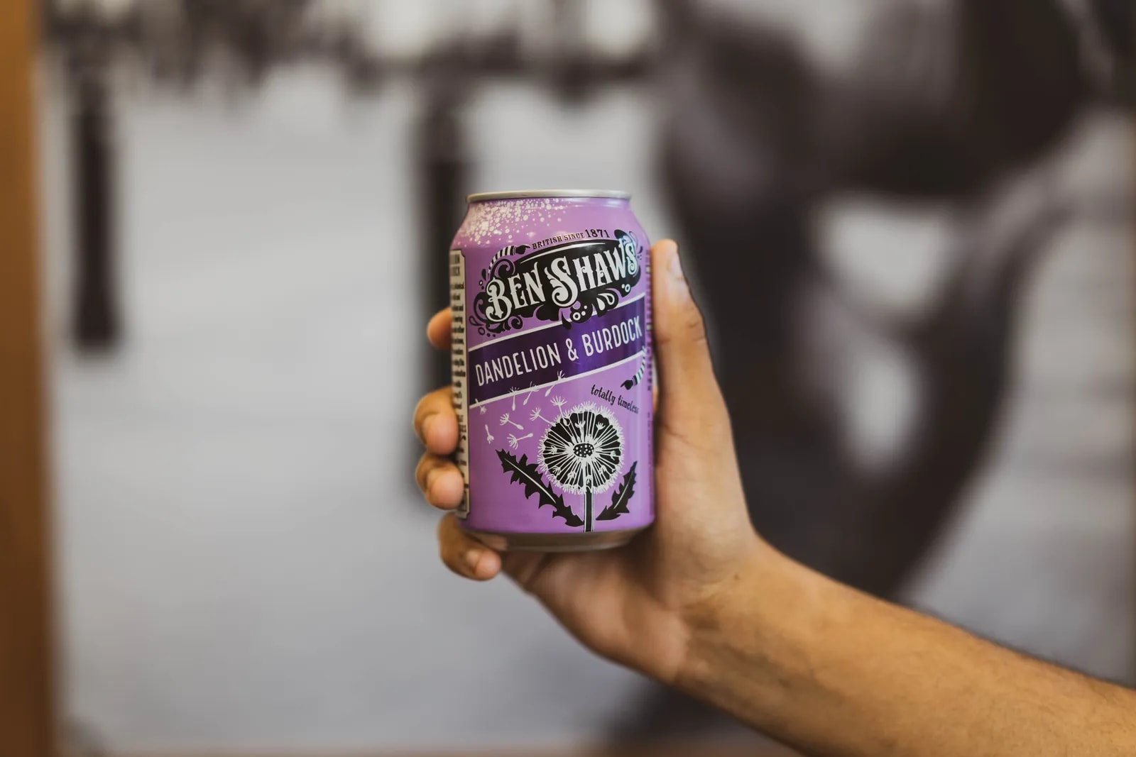 A hand holding a can of Ben Shaw’s dandelion & burdock