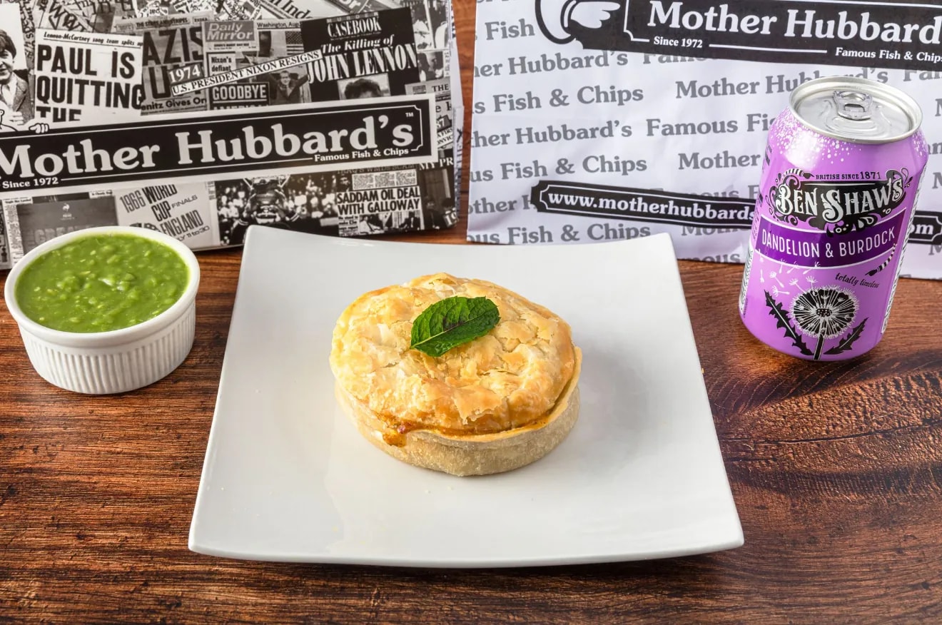 A chicken and mushroom pie on a square plate with mushy peas and a can of Ben Shaw’s