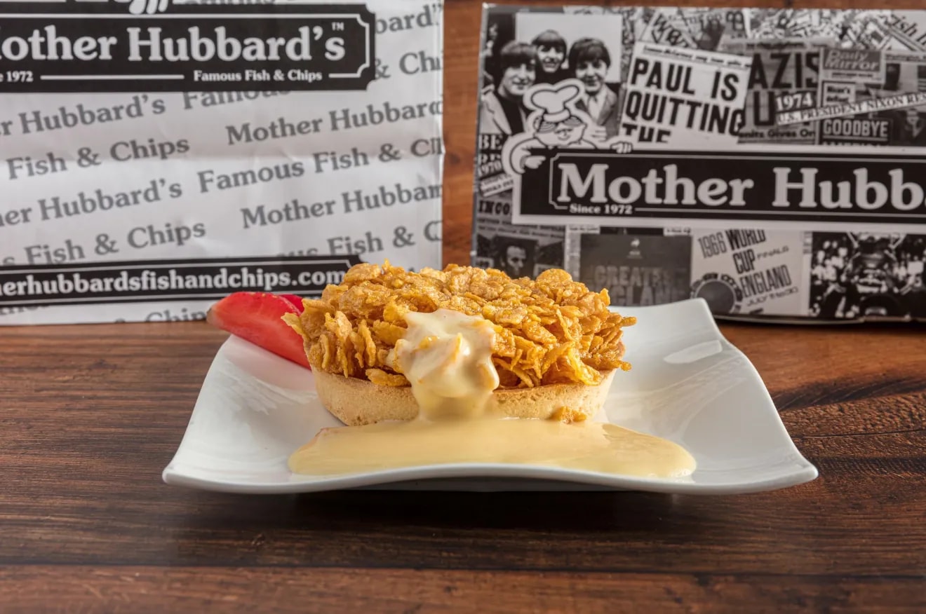 A cornflake tart with custard on a white plate