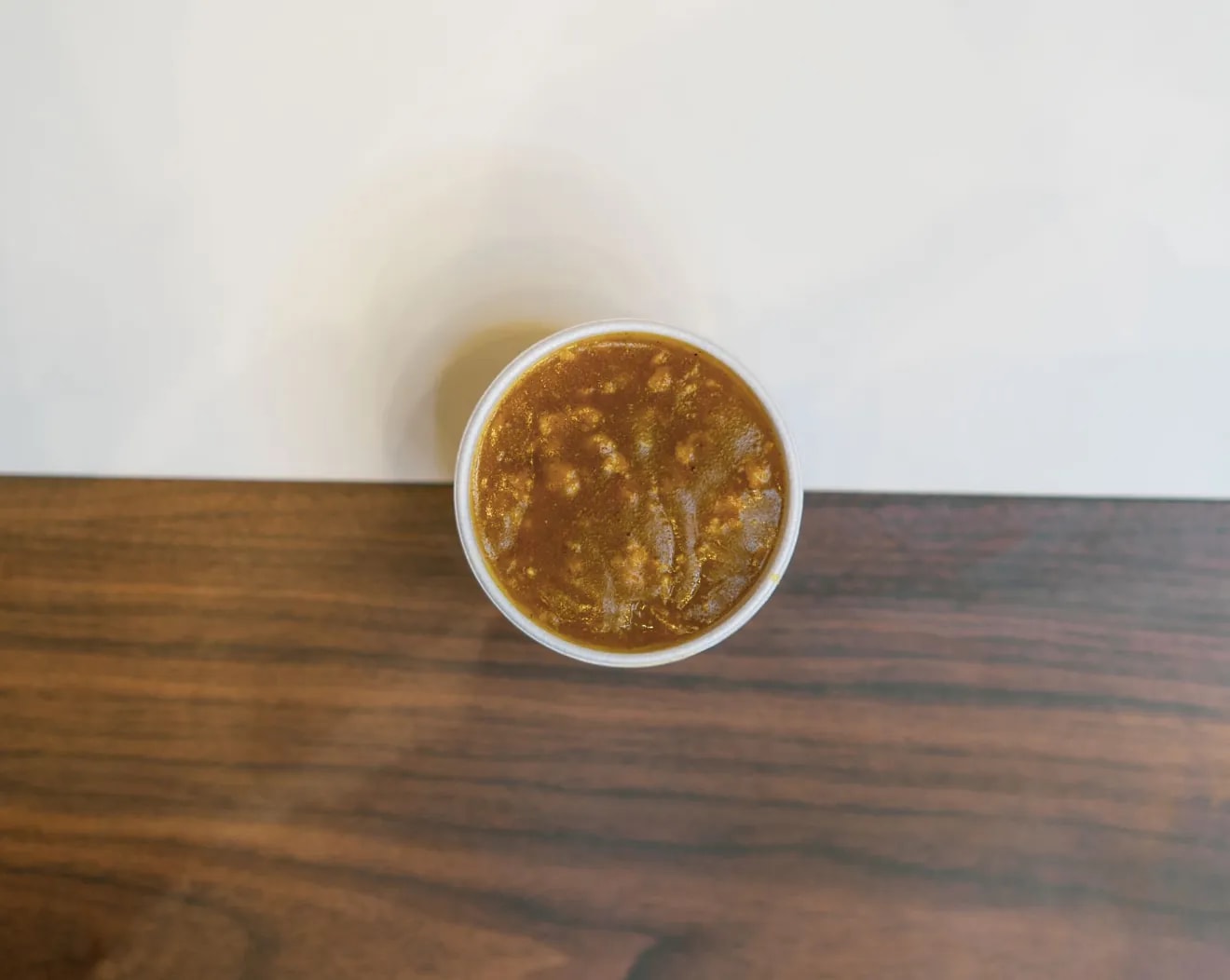 A pot of curry sauce on a wooden table