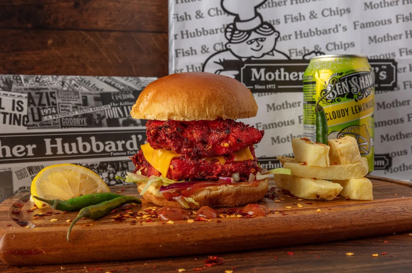 A fiery fish sandwich with cheese in a brioche bun, with chips, lemon, chillies and a can of Ben Shaw’s