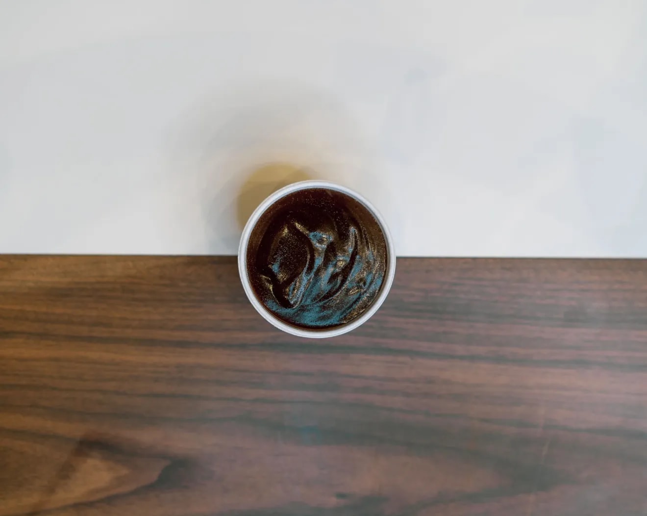 A pot of gravy on a wooden table