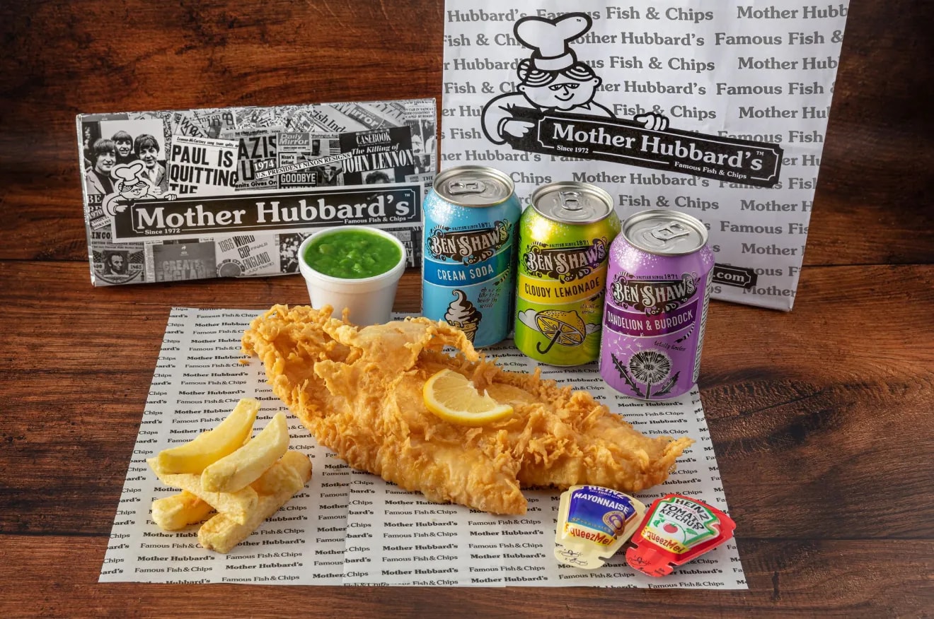 A special battered fish with a slice of lemon on chips, with mushy peas and three cans of Ben Shaw’s