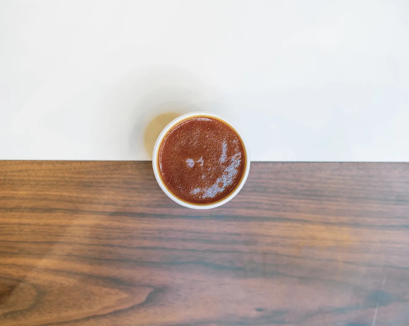 A pot of spicy curry sauce on a wooden table